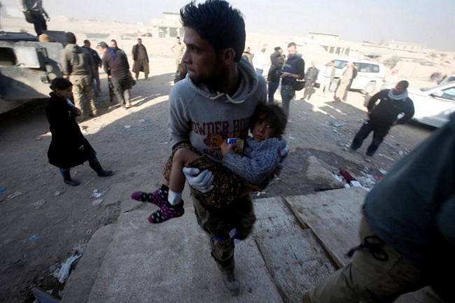 Thành viên của lực lượng đặc nhiệm Iraq bế một bé gái bị thương sau khi cứu sống em trong một cuộc giao tranh ở Mosul.
