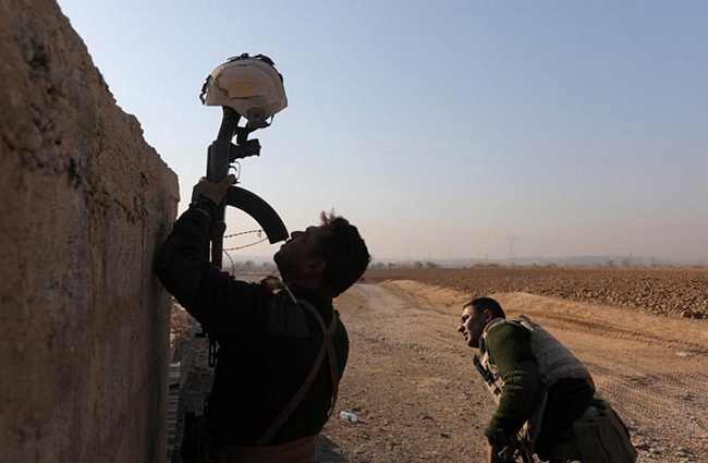 Lính Iraq dùng súng trường và mũ bảo hiểm làm mục tiêu giả để thu hút sự chú ý của các tay súng IS ở Al-Qasar, Đông Nam Mosul.