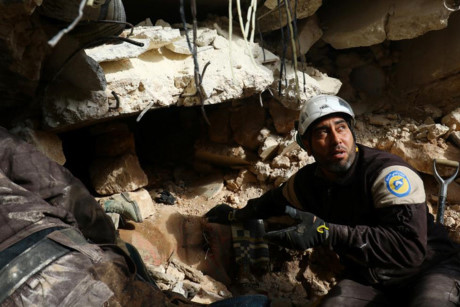  Một thành viên lực lượng “dân phòng” đang tìm người sống sót sau một đợt không kích ở thành phố Idlib, Syria.