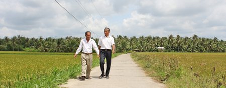 Ông Nghĩa (trái) đã hiến 100m2 đất để xây đường giao thông nông thôn và cùng đồng đội đứng ra quản lý tuyến đường.