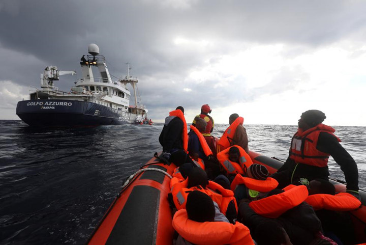 Các nhân viên cứu hộ đưa những người di cư lên chiếc tàu cá Golfo Azzurro.