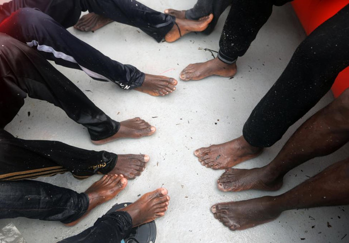 Những đôi bàn chân nhăn nheo vì giá lạnh của người di cư.