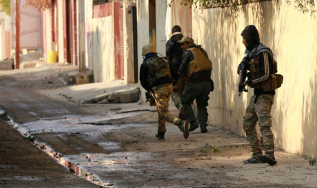 Binh sĩ Iraq di chuyển tránh các tay súng bắn tỉa trong trận chiến ở quận Mithaq, đông Mosul.