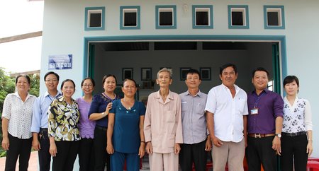 Bà Nguyễn Thị Bé Chín (thứ 6 bên trái, ấp Tân Bình, xã Tân Hội-TP Vĩnh Long) trong ngày vui được nhận nhà đại đoàn kết.
