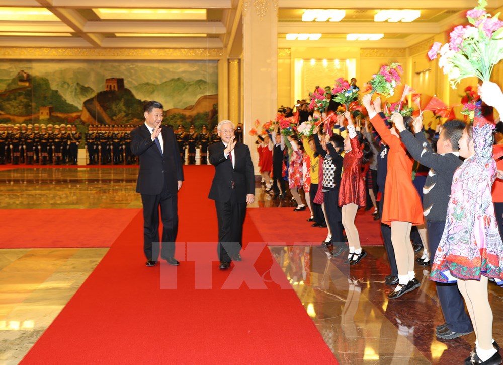 Tổng Bí thư Nguyễn Phú Trọng và Tổng Bí thư, Chủ tịch nước Trung Quốc Tập Cận Bình vẫy chào các cháu thiếu nhi tại lễ đón. (Ảnh: Trí Dũng/TTXVN)