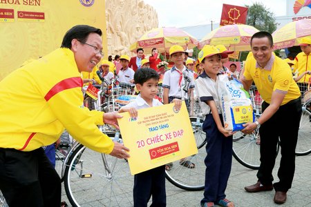 Ông Tăng Văn Mãi- Phó Bí thư thường trực Tỉnh ủy Bến Tre (trái) trao tặng 20 chiếc xe đạp cùng 20 phần quà cho học sinh nghèo hiếu học ở Bến Tre. Ảnh: DƯƠNG THU