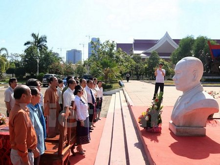 Các quan khách đang dành một phút mặc niệm trước bức Tượng bán thân của cố Chủ tịch Souphanouvong. (Ảnh: Phạm Kiên/Vietnam+)