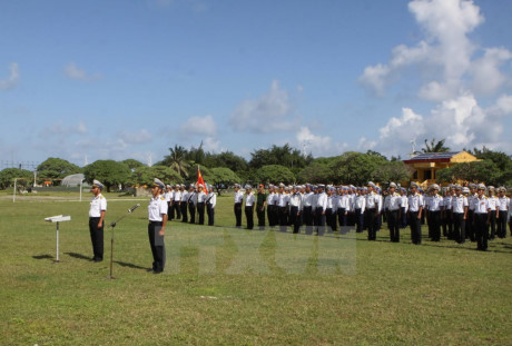 Quân và dân trên đảo Song Tử Tây thực hiện nghi lễ chào cờ đầu năm. (Ảnh: Dương Giang/TTXVN)