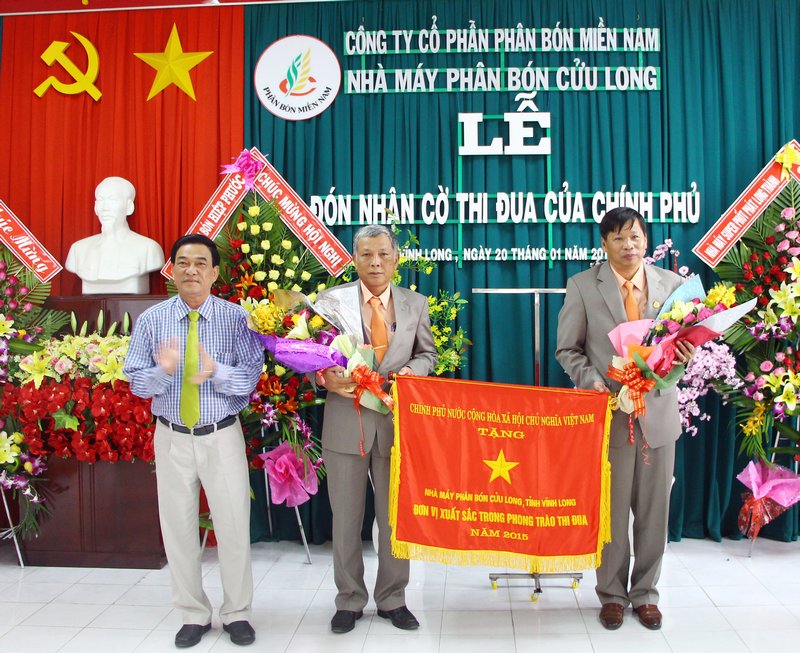 Ông Trần Hoàng Tựu- Phó Chủ tịch UBND tỉnh trao cờ thi đua Chính phủ cho lãnh đạo Nhà máy phân bón Cửu Long.