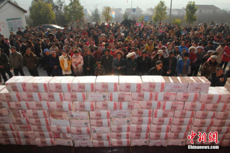 Ngày 14/1/2014, những người nông dân tại một ngôi làng ở Tứ Xuyên, Trung Quốc đứng chờ nhận tiền thưởng. Ngôi làng này có 340 hộ nông dân với tổng số tiền thưởng là 13 triệu nhân dân tệ (khoảng hơn 42 tỷ đồng), trong đó mức tiền thưởng cao nhất cho một nông dân là 300.000 nhân dân tệ (hơn 980 triệu đồng). (Nguồn: Chinanews)