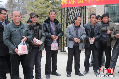 Ngày 30/11/2014, 17 hộ nông dân ở một huyện thuộc tỉnh Cam Túc (Trung Quốc) lên nhận tiền thưởng Tết trong sự ngưỡng mộ của những người khác. (Nguồn: Chinanews)