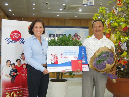 Bà Phan Dư Thúy Anh (trái) trao thưởng cho ông Trần Thái Bảo là khách hàng duy nhất ở Vĩnh Long trúng giải may mắn.