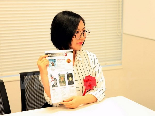 Tác giả Can Tiểu Hy bên áp phích của cuộc thi truyện tranh thế giới lần thứ 10. (Nguồn: Vietnam+)
