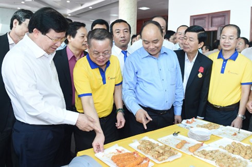 Thủ tướng Nguyễn Xuân Phúc và Phó Thủ tướng Trịnh Đình Dũng tham quan gian hàng thực phẩm chế biến từ tôm.