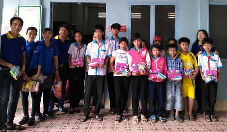 Anh Đăng (thứ 4 từ trái sang) tặng quà cho học sinh nghèo.