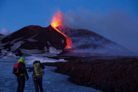 Khách du lịch và hướng dẫn viên đứng trước núi lửa Etna (Ảnh: Reuters). Theo nhà chức trách, núi lửa không gây nguy hiểm, và sân bay trong khu vực vẫn hoạt động bình thường. 