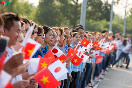 Các em Đoàn viên cầm cờ Việt Nam và Nhật Bản đứng đón chào Nhà vua Nhật Bản và Hoàng hậu ở hai bên đường.