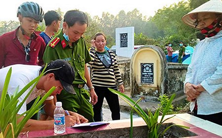 Cơ quan chức năng khám nghiệm tử thi nơi chôn bé Đinh Lam Thiên.