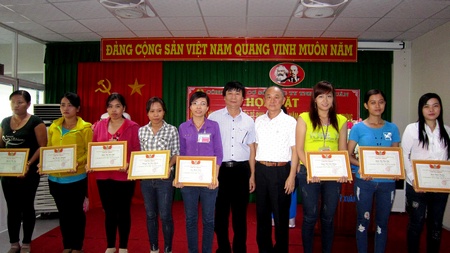 Ông Trần Triều Kang- Tổng Giám đốc (phải) và ông Nguyễn Văn Trí- Chủ tịch CĐCS Công ty (trái) trao giấy khen “Giỏi việc công ty- Đảm việc nhà” cho các nữ công nhân đạt danh hiệu.