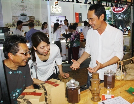 Ông Inada Shoichi (bìa trái) đang thưởng thức cà phê tại hội chợ.