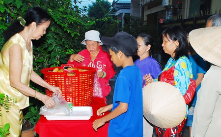 Mỗi sáng, bà Kim Anh phát bánh mì miễn phí cho bà con lao động nghèo trong huyện.