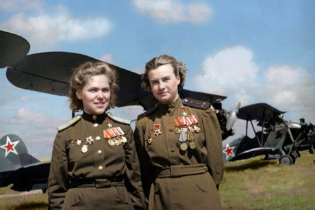 Các nữ sĩ quan không quân Xô viết gắn huân chương Anh hùng Liên Xô trên áo và đứng trước các máy bay 2 tầng cánh Polikarpov Po-2.