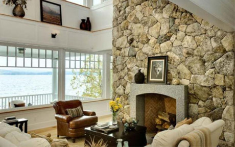 Phòng khách được trang trí với màu sắc trung tính, với điểm nhấn là lò sưởi bằng đá tự nhiên
