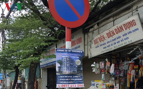 Vô tư treo quảng cáo trên cột tín hiệu giao thông ở Hà Nội.