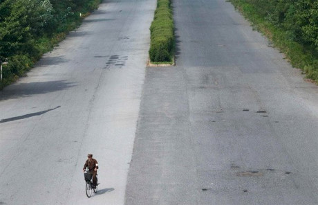 Con đường cao tốc chỉ với một bóng người đi xe đạp. Người Triều Tiên thường di chuyển bằng xe buýt, xe đạp hoặc đi bộ.