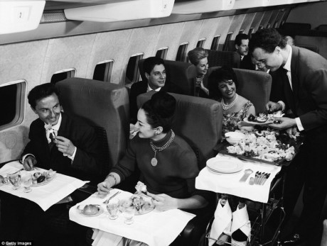 Hành khách ở khoang hạng nhất của một máy bay thương mại (Boeing) đang được phục vụ bữa ăn, năm 1950.
