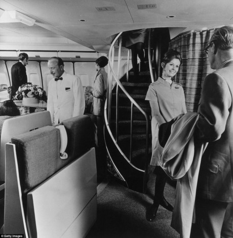 Hành khách đứng phía trước một cầu thang xoắn ốc dẫn đến phòng tầng trên của chiếc Boeing 747 Monarch, ảnh chụp năm 1970.