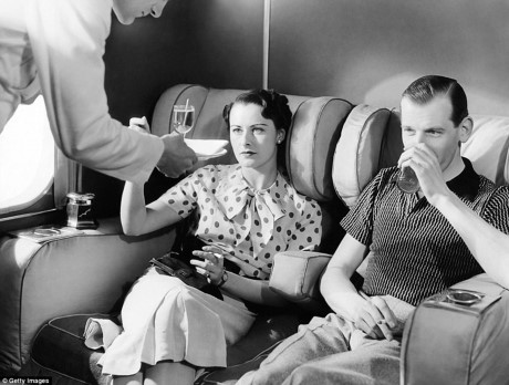 Một cặp vợ chồng thưởng thức cocktail trong phòng hút thuốc của một máy bay ở London, Anh, năm 1930.