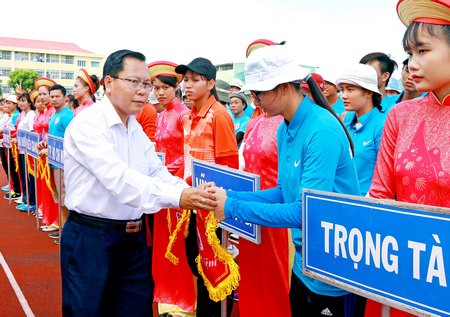 Ông Nguyễn Mạnh Hùng- Phó Chánh Văn phòng UBND tỉnh Vĩnh Long trao cờ lưu niệm cho đoàn VĐV tỉnh Vĩnh Long tại lễ khai mạc giải.