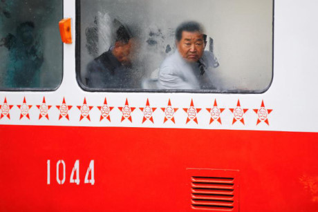 Người đàn ông nhìn qua cửa sổ xe điện trong một ngày mưa ở Bình Nhưỡng.