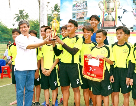 Ông Trần Dũ Lộc- Phó Phòng GD- ĐT TP Vĩnh Long trao cúp vô địch cho đội Trường THCS Nguyễn Trường Tộ.