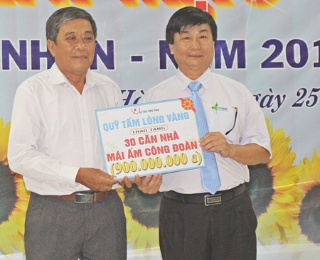 Ông Nguyễn Thành Nhân- Chủ tịch Công đoàn Các Khu công nghiệp tỉnh (trái) trao tặng biểu trưng hỗ trợ 30 căn nhà đến Công đoàn cơ sở Công ty TNHH Tỷ Xuân. 