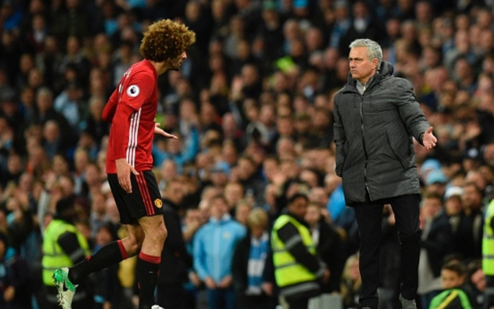 Fellaini giải thích với HLV Jose Mourinho và nhận được cái nhìn bực tức từ ông thầy của mình (Ảnh: Getty).