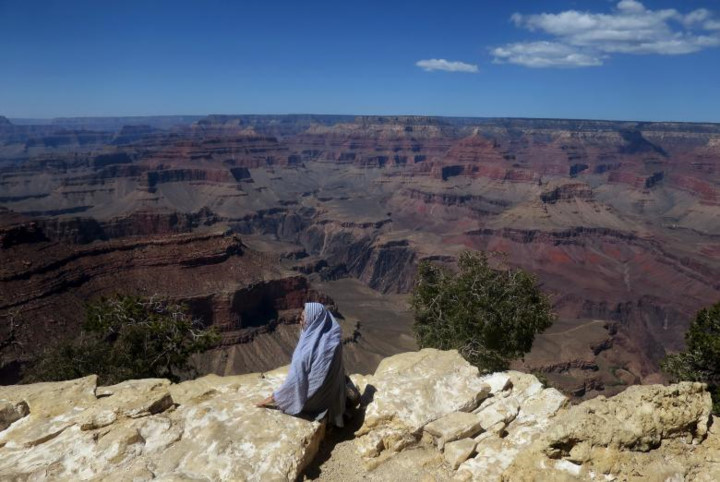 Một người phụ nữ ngồi trên dãy núi ở rìa nam công viên quốc gia Grand Canyon.