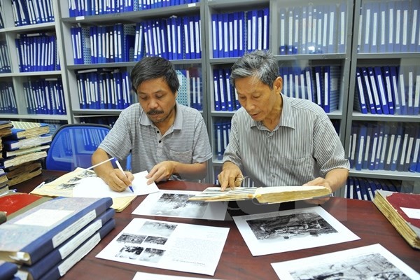 Nghệ sỹ nhiếp ảnh Chu Chí Thành nghiên cứu tư liệu tại Ban Biên tập Ảnh (TTXVN) để xây dựng cụm tác phẩm 