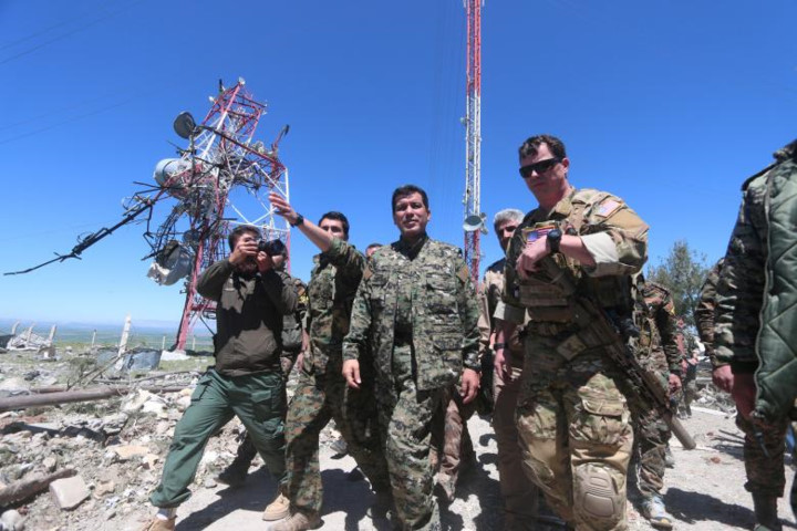 Một chỉ huy của lực lượng Mỹ (phải) và một chỉ huy của YPG (giữa) cùng thị sát khu vực bị tàn phá sau cuộc không kích của Thổ Nhĩ Kỳ ở Mount Karajukh, Syria hôm 25/4.