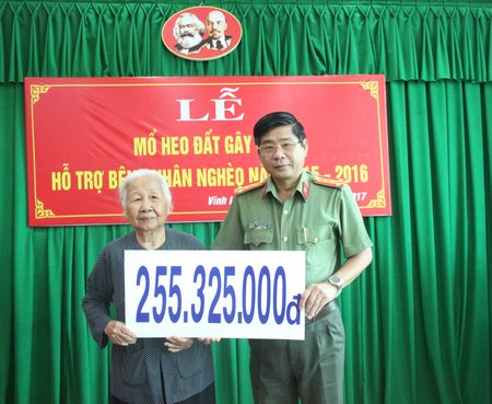 Đại tá Nguyễn Văn Hiểu- Tỉnh ủy viên, Phó Giám đốc Công an tỉnh trao số tiền mổ heo đất cho đại diện Hội Người khuyết tật, bảo trợ trẻ mồ côi và bệnh nhân nghèo tỉnh. 