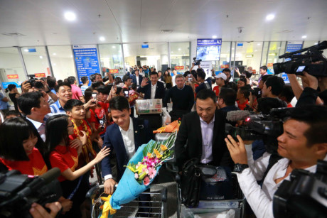 Phó chủ tịch VFF Trần Quốc Tuấn (phải) và Quang Hải tiến ra sảnh trong sự chào đón của người hâm mộ