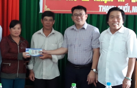Ông Mai Hữu Ánh (bìa phải) và ông Võ Trí Nhân- Giám đốc Ngân hàng TMCP Sài Gòn chi nhánh Vĩnh Long (đứng thứ 2) trao tiền cho vợ chồng ông Bé Tư.