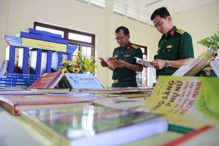 Đại úy Trần Đạt Danh (bên phải) luôn tìm tòi, học hỏi để nâng cao trình độ, đáp ứng tốt nhiệm vụ của cán bộ chính trị.