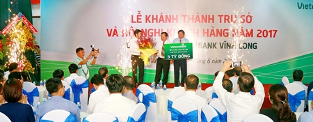 Chủ tịch UBND tỉnh- Nguyễn Văn Quang (giữa) tặng hoa cho ông Nghiêm Xuân Thành- Chủ tịch HĐQT Vietcombank.