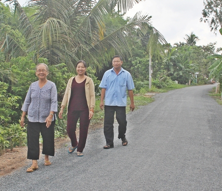 Bà Phạm Thị Thu Cúc (trước) rất ủng hộ việc huy động sức dân và hiến 45m2 đất làm đường.