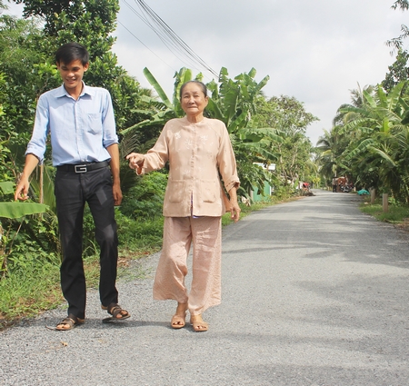 Bà Lê Thị Lùng (phải) đã hiến 150m2 đất để Nhà nước mở rộng và nhựa hóa đường giao thông.
