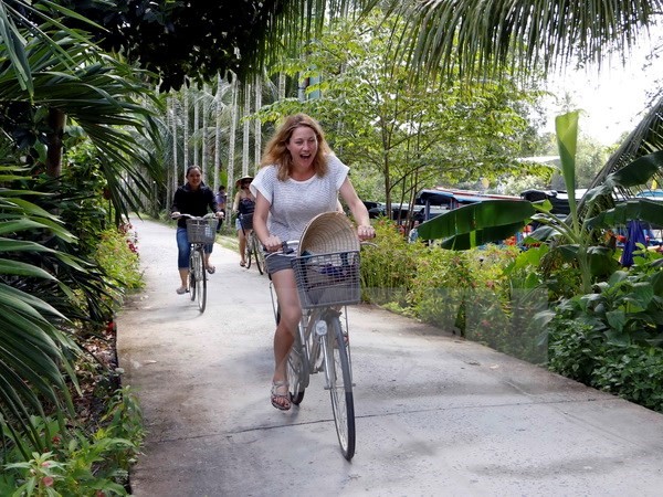 Du khách nước ngoài đi dạo bằng xe đạp tại homestay Út Hiên, quận Cái Răng. (Ảnh: Thanh Liêm/TTXVN)