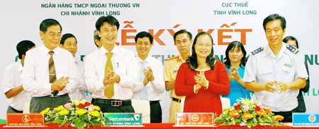 Đại diện 4 đơn vị (từ trái sang): Kho bạc Nhà nước, Vietcombank Vĩnh Long, Cục Thuế và Hải quan trong buổi ký kết. 