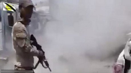 Hình ảnh trích xuất từ một video ghi lại cảnh một nam giới mặc quân phục Iraq nổ súng bắn hạ một người đang quỳ. Nguồn: AP.